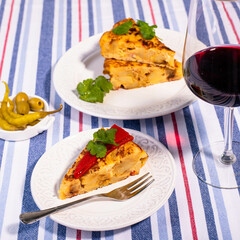 Traditional Spanish snack tortilla patatas served with red piquillo pepper and a glass of wine.