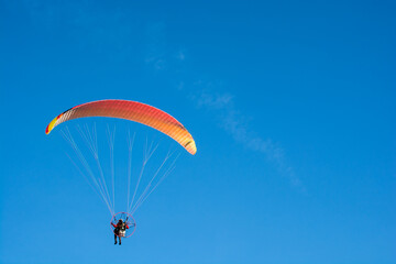 paraglider on the blue sky background
