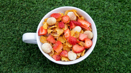 cereal bowl with fruit on grass background