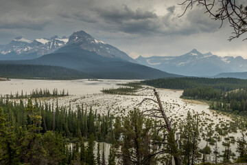 Rain and heavy clouds churn up the silt in the river, as seen from Howes Pass Lookout Banff National Park Alberta Canada