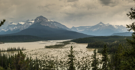 Rain and heavy clouds churn up the silt in the river, as seen from Howes Pass Lookout Banff National Park Alberta Canada