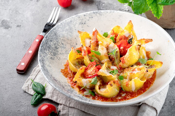 Pasta Conchiglionii filled with minced meat with tomatoes, bolognese sauce and Parmesan. An...