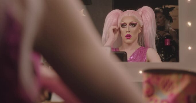 Drag Queen putting on Wig Backstage, looking in Mirror