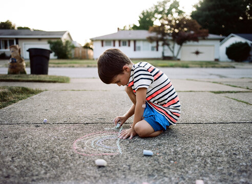 boy chalks in driveway