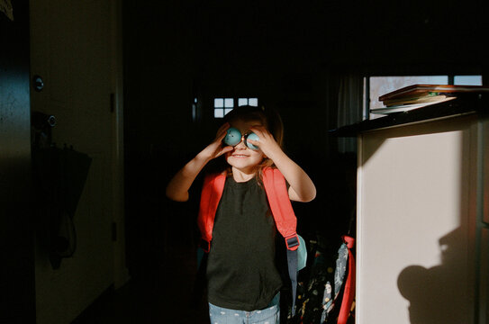 little girl covers her eyes getting ready for school