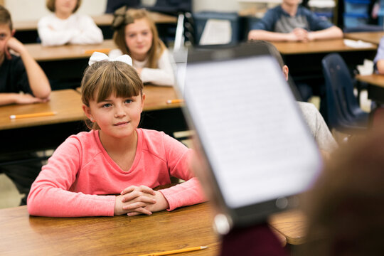 Classroom: Students Listen As Teacher Reads From Digital Tablet