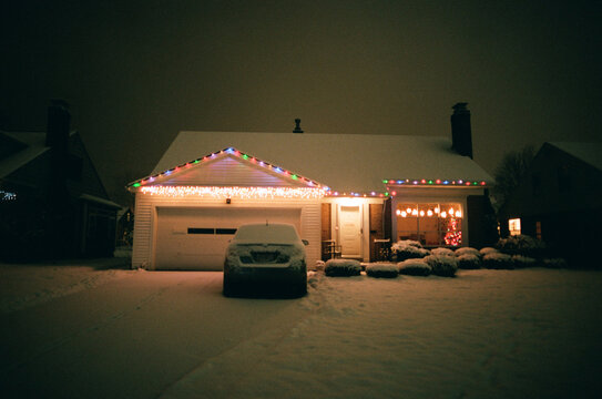 house with holiday lights and snow