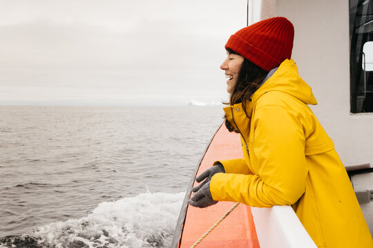 Woman Looks Out From Boat Smiling