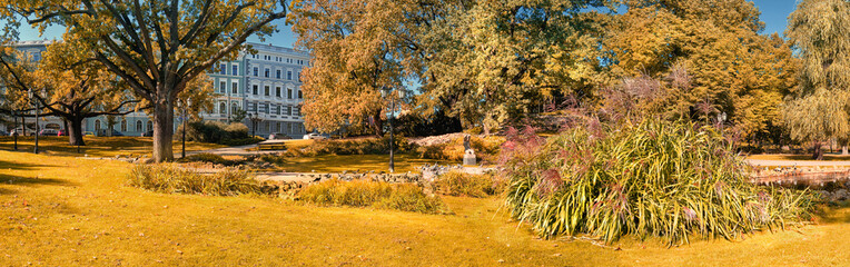 Riga river canal in Riga, Latvia in Autumn. Central city park on a sunny day. Panoramic banner...