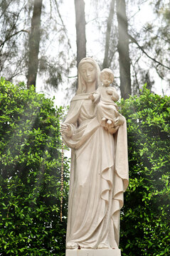 Statue of Our lady virgin Mary with Child Jesus located in front of the catholic church with natural background, Thailand. selective focus.