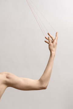 Woman's hand with red threads which symbolized control and manip