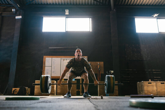 Athlete lifting a heavy barbell in the gymnasium