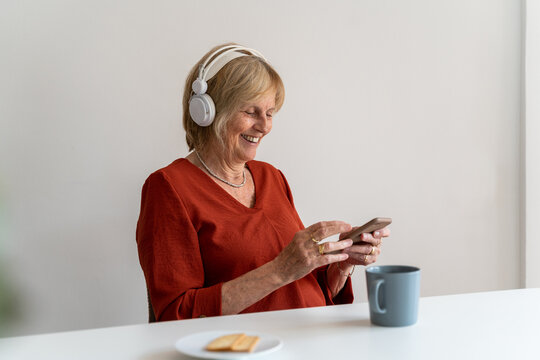 Senior woman using phone and listening to music 