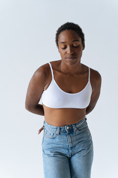 studio portrait of black woman in blue jeans and white bra