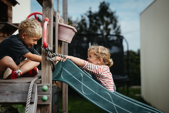 Brother and sister playing on a slide