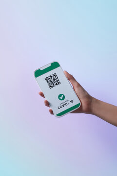 Hand-holding smartphone with health passport for covid-19.