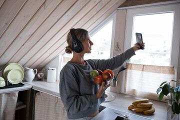 Positive woman taking selfie with apples