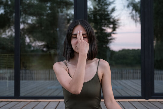 Woman touching Third Eye Chakra during meditation