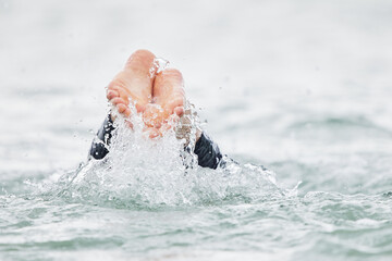 sea swimmers feet splash into water from a dive