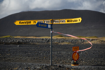 A sign at a crossroad of rough desert roads and the closed access to the site of the Bárðarbunga...