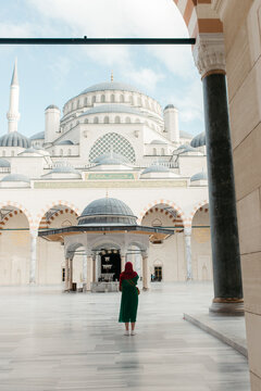 hijabi woman walking in a mosque yard. 