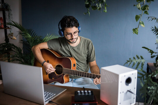 Young Musician Playing Classic Guitar And Composing New Music