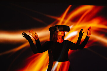 Girl in VR headset standing near glowing background 