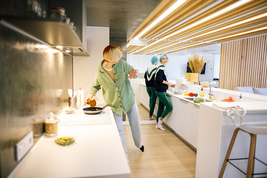 Lesbian couple making dish in kitchen together 