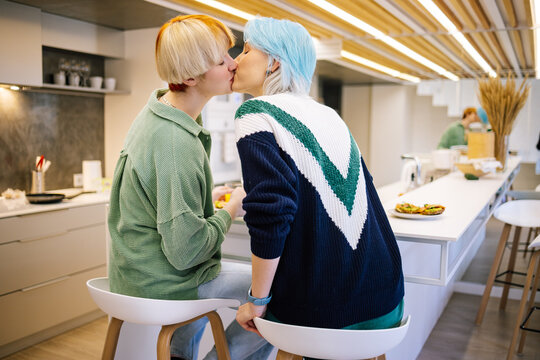 Girls kissing during lunch in kitchen 