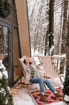 Relaxed woman with french Bulldog sitting in deckchair