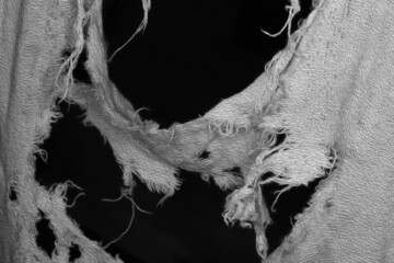 Ripped ragged and frayed cloth texture in closeup