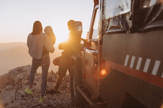 Traveling family admiring sunset in mountains