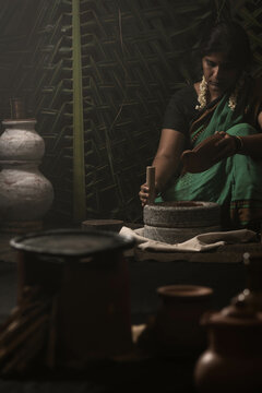 A woman grinding millet flour using grinding stone