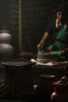 A woman grinding millet flour using grinding stone