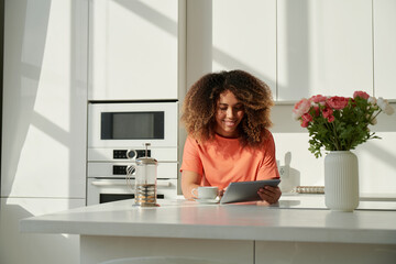 Smiling young woman enjoys using digital tablet