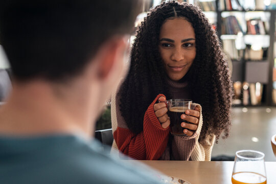 Black woman drinking coffee in a modern loft