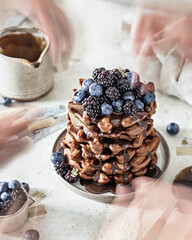 Stack of chocolate waffles with berries. The concept of movement in the moment