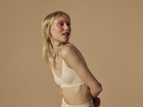 cheerful model looks aways with a glowing and healthy skin 