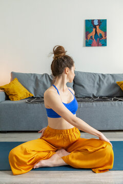 Flexible female stretching in Parivritta Sukhasana pose