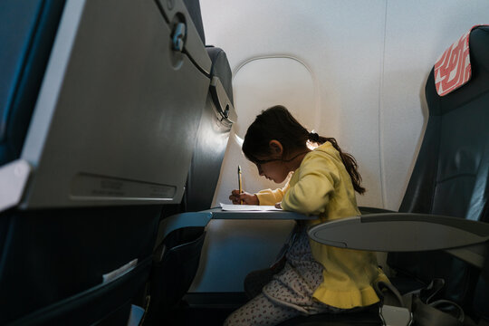 Girl studying and going over homework in the plane cabin