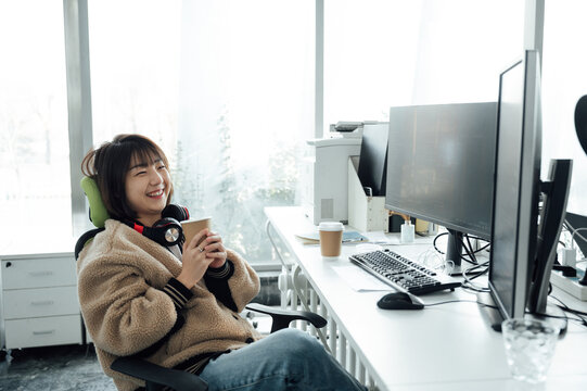 Young business woman holding coffee cup in office