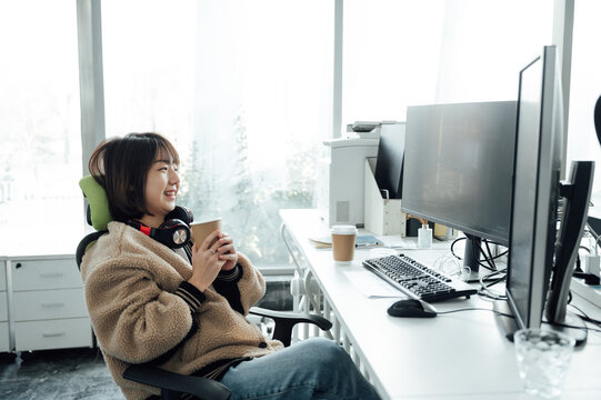 Young business woman holding coffee cup in office