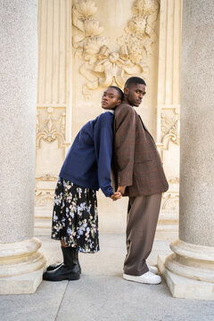 Portrait Of A Young Black Couple Leaning On Their Backs.