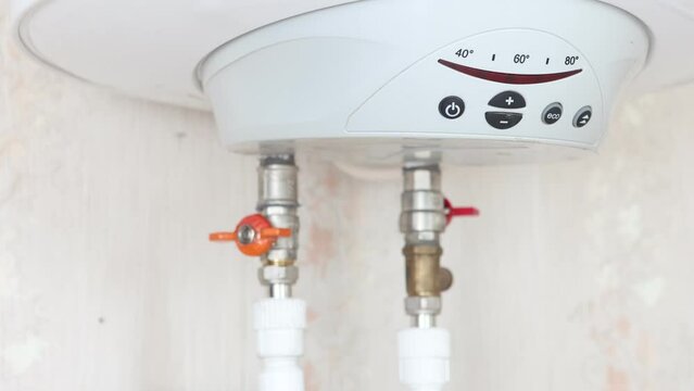 Plumber is connecting boiler to domestic water supply system.