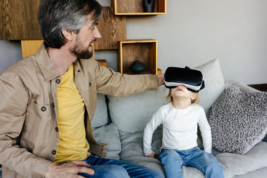 Father showing child video in VR goggles 