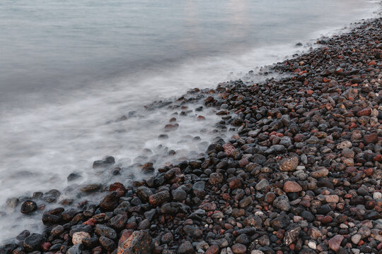 The white waves on the gravel beach.