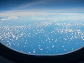 Beautiful altocumulus clouds view from an aircraft window. - obrazy, fototapety, plakaty