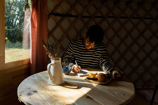 man writing on notebook
