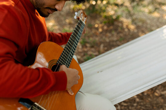 close up of a young man playing guitar 
