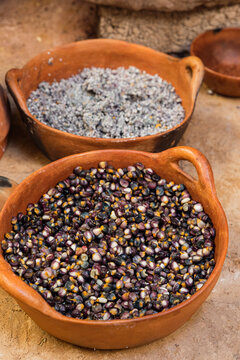 two clay pots with kernels and grains